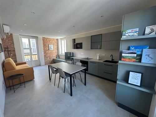 a kitchen and living room with a table and chairs at Casa PORTA LANERO di Francesco e Alessandro in Nizza Monferrato