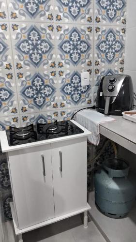 a kitchen with a stove and a wall at Kitnet Muriqui 1 in Mangaratiba