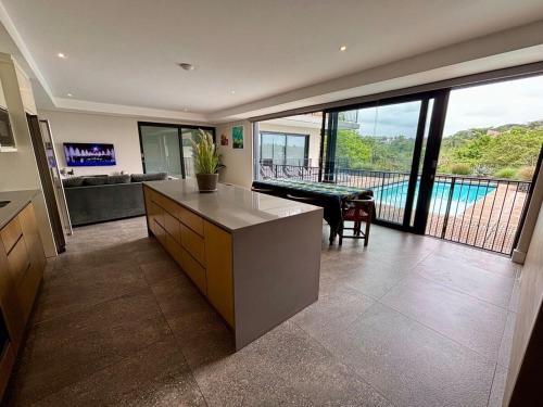 een grote keuken met uitzicht op een woonkamer bij Reef House in Ballito