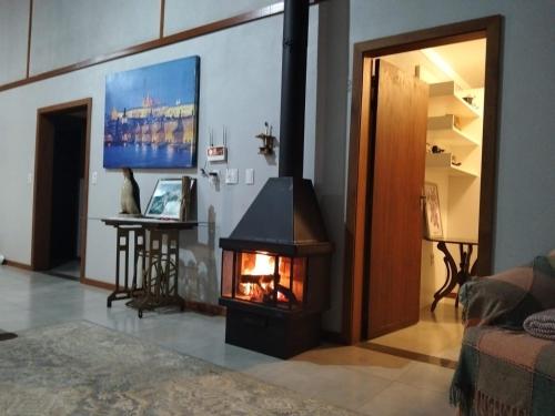 a living room with a fireplace in the middle at Xixo Casa do Vale Descanso e Natureza Em Gramado in Gramado