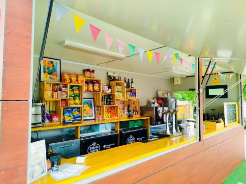 una tienda con una fachada con banderas en el techo en O Pedrouzo Base Camp, en O Pino 