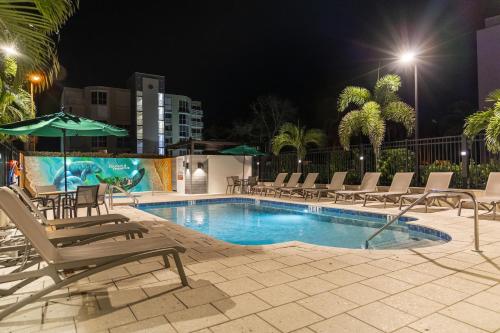 ein Swimmingpool mit Stühlen und Sonnenschirmen in der Nacht in der Unterkunft The Fold Hotels Indian Shores in Clearwater Beach