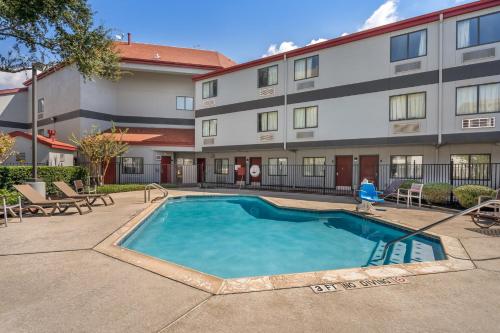 a swimming pool in front of a building at Red Roof Inn Houston Brookhollow in Houston