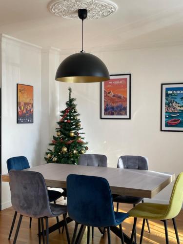 une salle à manger avec une table et un sapin de Noël dans l'établissement Bel Appartement , proche tram place de Strasbourg accès centre ville, plages, à Brest