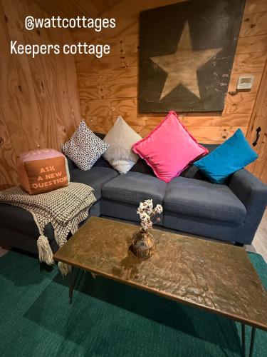 a living room with a couch and a coffee table at Keepers Cottage in Ipswich