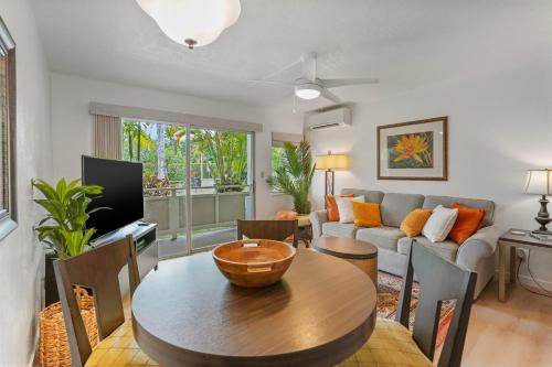 a living room with a table and a couch at Kahaki Hale in Kapaa