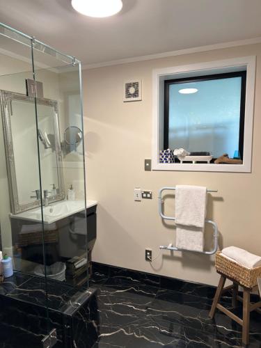 a bathroom with a shower and a sink and a mirror at Incredible mountain & sea views in Mapua