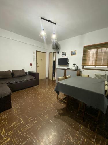een woonkamer met een bank en een tafel bij Departamento 2 ambientes en MIRAMAR in Miramar