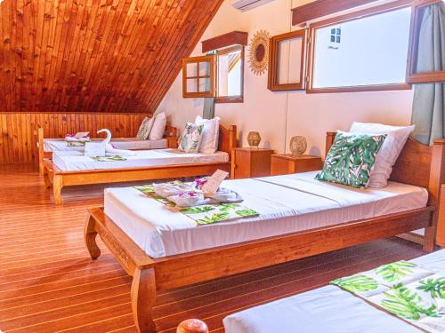 a room with three beds and a large window at Le Mohana - L'évasion tropicale de l'Est in Saint-André