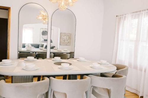 a white dining room with a white table and chairs at The Hillside - Historic Tudor retreat in SLC in Garden Towers Condominium