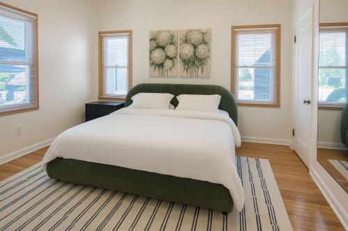 a bedroom with a large bed in a room with windows at The Hillside - Historic Tudor retreat in SLC in Garden Towers Condominium