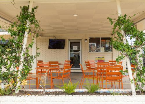 a group of chairs and tables in a restaurant at Driftwood Motel in Bay Saint Louis