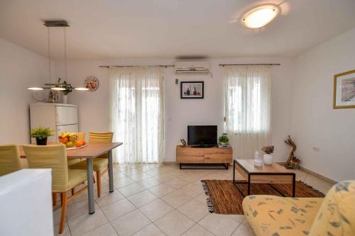 a kitchen and living room with a table and a television at Apartments in Stara Baska - Insel Krk 34433 in Stara Baška
