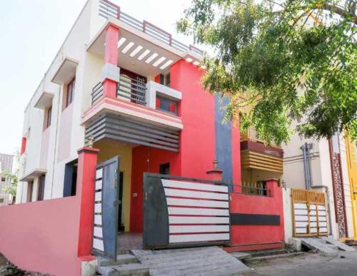 a red and white house with a garage at Hotel O Moondrumavadi Bus Station Madurai Formerly Umasankar Abodes in Madurai