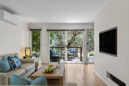 ein Wohnzimmer mit Sofa und Fernseher in der Unterkunft Scribbly Gums Callala Beach in Callala Beach