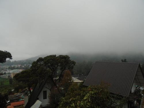 a foggy view of a city with houses and trees at B&B Nuwara eliya in Nuwara Eliya