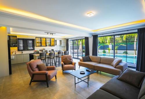 een woonkamer met een bank en stoelen en een keuken bij Dalyan Villa Oliva in Dalyan