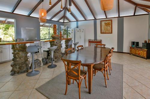 una sala da pranzo con tavolo e sedie in legno di Villa Joyce - Pool & Spa a Mahina