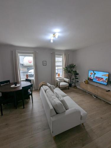 a living room with a white couch and a tv at Tandragee Stays - 1 Bed Apartment && 2 Bed Apartment - Portadown in Tandragee
