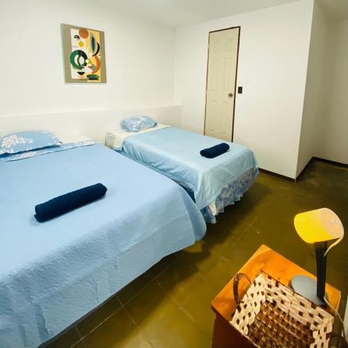 Dos camas una al lado de la otra en una habitación. en Hostal La casa de Ross, en Santa Ana