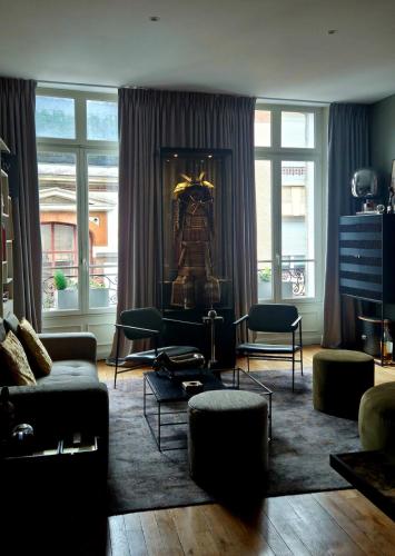 a living room with a couch and chairs and windows at Le Galeriste - parking inclus in Reims
