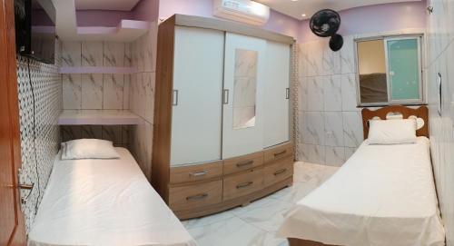 Dos camas en una habitación con paredes moradas. en barbershopcavalheiro, en Belém