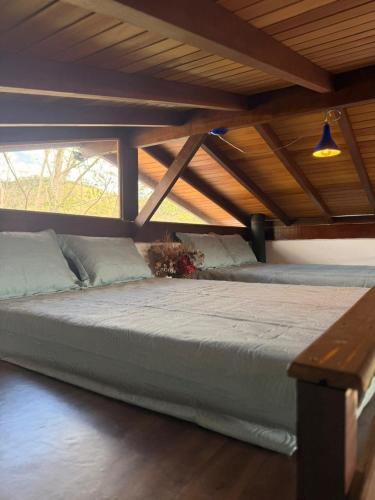 a large bed in a room with a wooden ceiling at Casa Quintal Sebollas - Paraíba do Sul in Paraíba do Sul