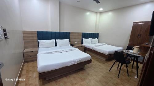 a bedroom with two beds and a table and a chair at fab THE MALEEN New Delhi in New Delhi