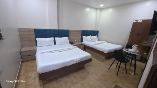 a bedroom with two beds and a desk and a chair at fab THE MALEEN New Delhi in New Delhi