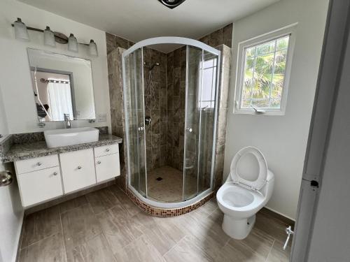 a bathroom with a shower and a toilet and a sink at Beach house oceacn front Rosarito in Rosarito
