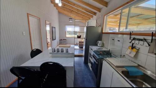 a kitchen with a stove and a counter with chairs at Huella de Luna in Valdivia