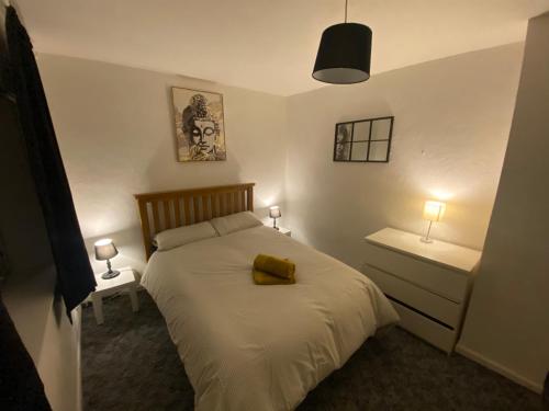 ein Schlafzimmer mit einem Bett mit einem gelben Objekt darauf in der Unterkunft meadow house close to city center in Belfast