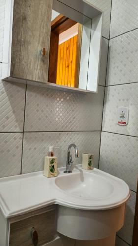 a bathroom with a sink and a mirror at Studio Marangoni Hospedagem in Treze Tílias
