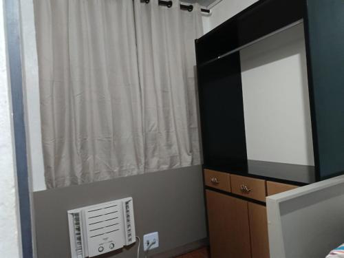 a bedroom with a large television and a window at AP da val 3 no coração de Manaus in Manaus