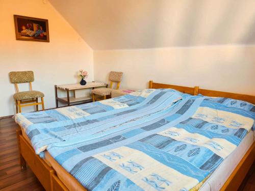 ein Bett mit einer blauen und weißen Bettdecke in einem Schlafzimmer in der Unterkunft Holiday home Balatonbereny - Balaton 18113 in Balatonberény