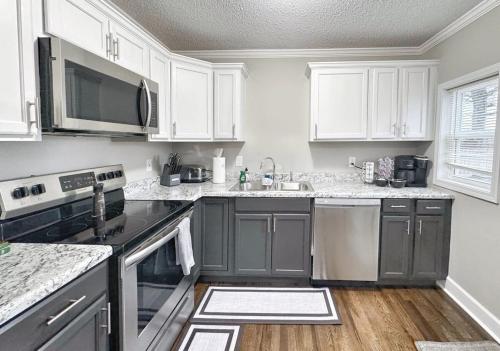 a kitchen with stainless steel appliances and white cabinets at Stylish 2BR in Decatur - Big Deck - Pets OK - Fire Pit in Decatur