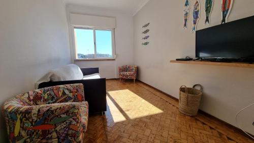 a living room with a chair and a flat screen tv at Sun House Belem - Free Parking and View Tower in Lisbon