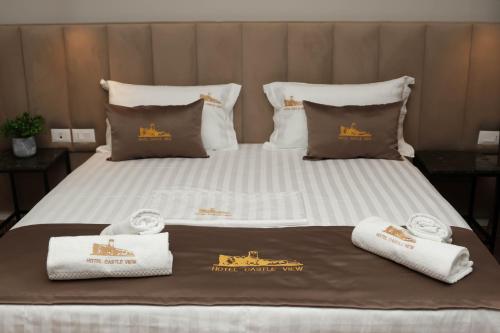 a large bed with towels on top of it at Hotel Castle View in Krujë