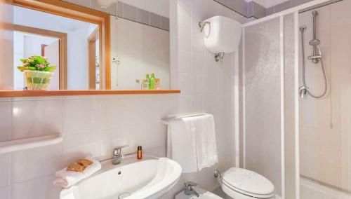 a white bathroom with a toilet and a sink at Apartment in Follonica - Toskana 44106 in Casa SantʼEugenia
