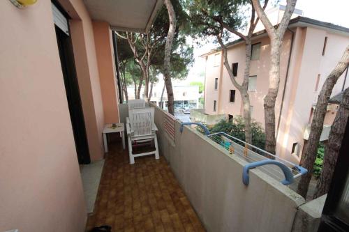 a balcony of a house with a fence and a chair at One-Bedroom Apartment in Rosolina Mare V in Rosolina Mare