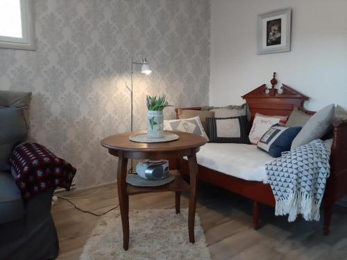 Villa Vuorenpää في Tammela: غرفة معيشة بها سرير وطاولة
