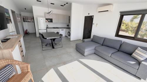 een woonkamer met een bank en een tafel bij Villa Sotavento Ocean Views Modern New Apartment in Natural Park in Playa Jandia