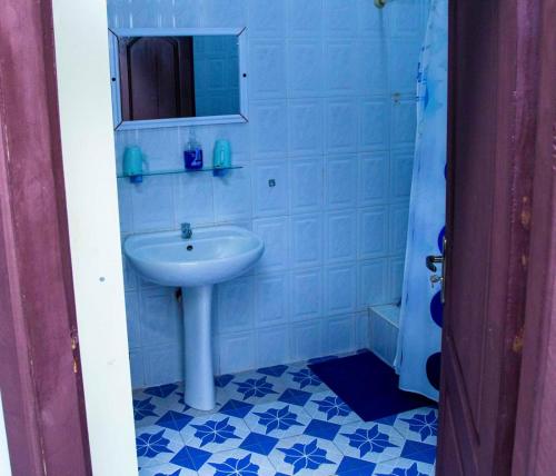 un baño con lavabo y espejo en Eliogemi Guest Room, en Gbawe