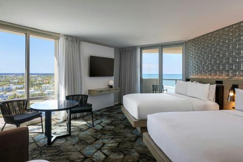 a hotel room with two beds and a table at Renaissance Daytona Beach Oceanfront Hotel in Daytona Beach
