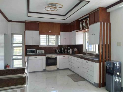 eine große Küche mit weißen Schränken und weißen Geräten in der Unterkunft House & Swimming Pool on a Hill in Galicias