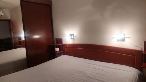 a bedroom with two beds and two lights on the wall at Lux apartman sa garažom in Banja Luka