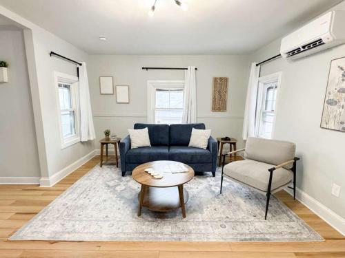 普罗维登斯Jennifer's Modern & Comfy Broadway Retreat的客厅里有一张蓝色的沙发和一张桌子