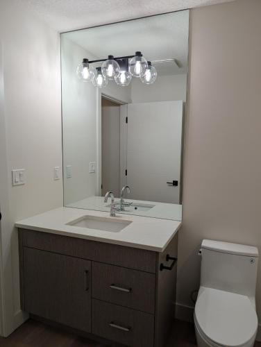 a bathroom with a sink and a mirror at 21 Greenwich Common NW Calgary Alberta in Calgary