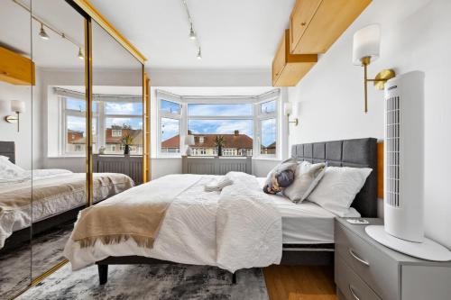 a bedroom with two beds and a mirror at Quincy's Homes in Dartford