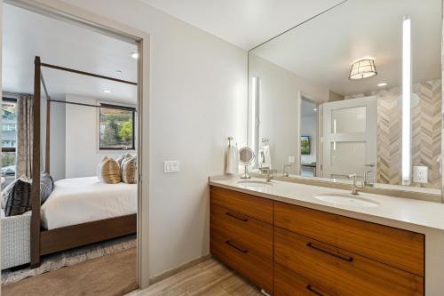 een badkamer met een bed, een wastafel en een spiegel bij Main Street Modern at Old Town in Park City